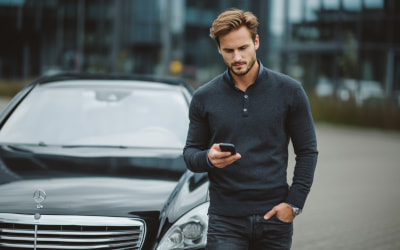 мужчина с телефоном перед машиной